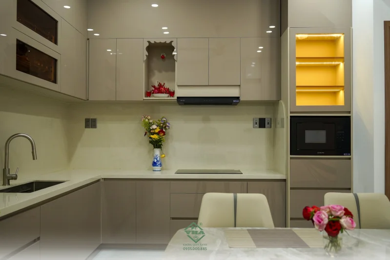 Thiết kế bếp nhà phố hiện đại với hệ tủ bếp Acrylic chữ L và không gian nấu ăn tối ưu.